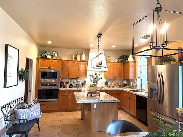 5170 Coronado St, Chowchilla, CA 93610 - kitchen featuring a sink, appliances with stainless steel finishes, brown cabinetry, and a kitchen island
