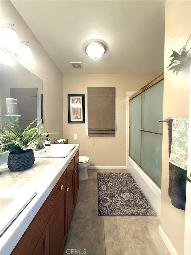 5170 Coronado St, Chowchilla, CA 93610 - full bathroom featuring visible vents, double vanity, toilet, bath / shower combo with glass door, and a sink