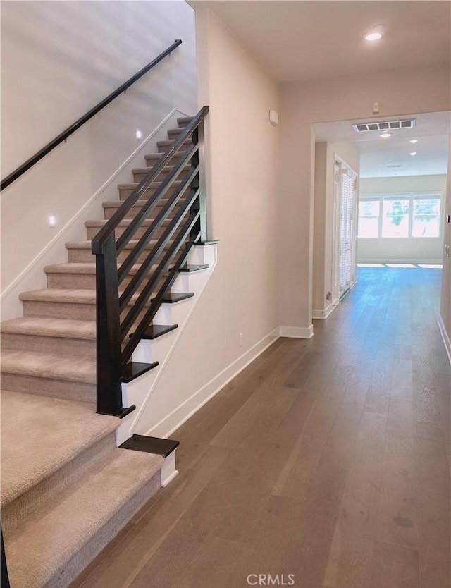 stairs featuring baseboards, recessed lighting, hardwood / wood-style floors, and visible vents
