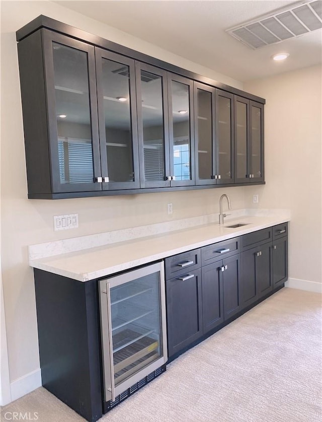 bar featuring light carpet, a sink, baseboards, wine cooler, and visible vents