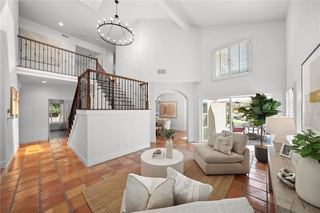 living area with a towering ceiling, a chandelier, stairway, arched walkways, and recessed lighting
