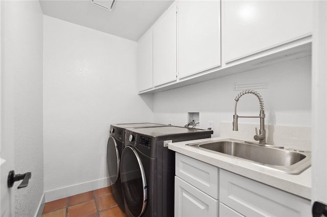 clothes washing area featuring cabinet space, washer and dryer, baseboards, and dark tile patterned flooring