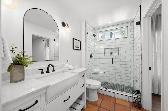 bathroom with a shower stall, toilet, vanity, and tile patterned floors