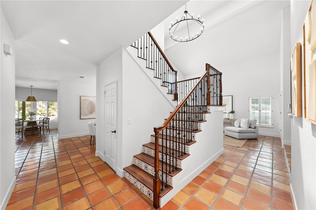 stairway with a chandelier, recessed lighting, baseboards, and tile patterned floors