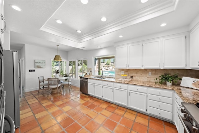 kitchen with a tray ceiling, stainless steel appliances, backsplash, crown molding, and recessed lighting