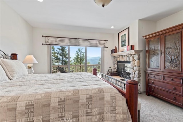 bedroom with light colored carpet, recessed lighting, access to exterior, and a fireplace