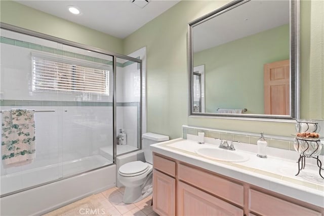 bathroom featuring vanity, tile patterned flooring, shower / bath combination with glass door, and toilet