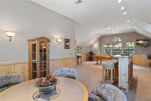 dining room with wooden walls, a wainscoted wall, billiards, visible vents, and vaulted ceiling