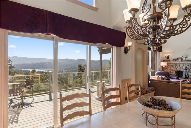dining space with plenty of natural light, arched walkways, a mountain view, and an inviting chandelier