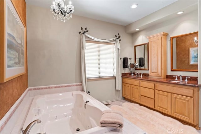 bathroom with double vanity, recessed lighting, a jetted tub, and a sink