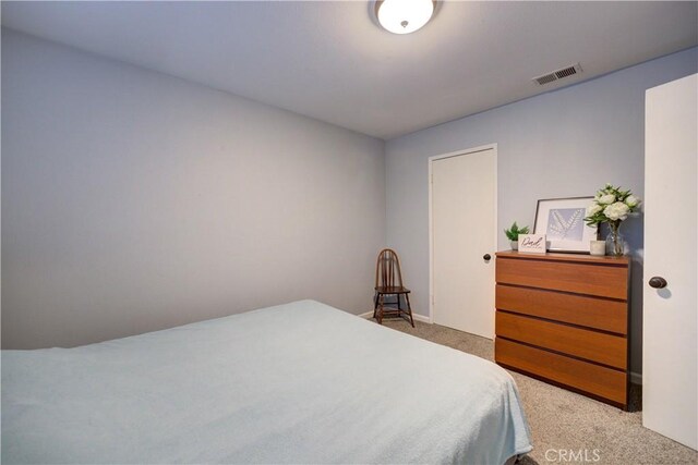 bedroom featuring visible vents, baseboards, and light carpet
