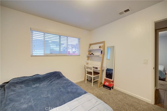 carpeted bedroom with visible vents and baseboards