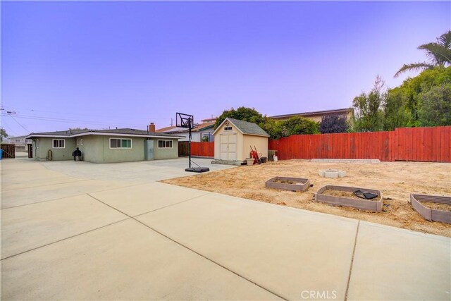 exterior space featuring a garden, a shed, a patio, and fence