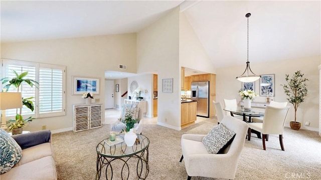 living area featuring visible vents, light carpet, baseboards, and high vaulted ceiling