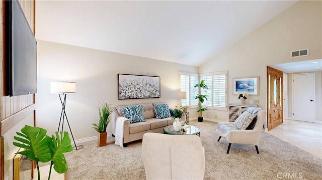 living area featuring baseboards, visible vents, high vaulted ceiling, and light colored carpet