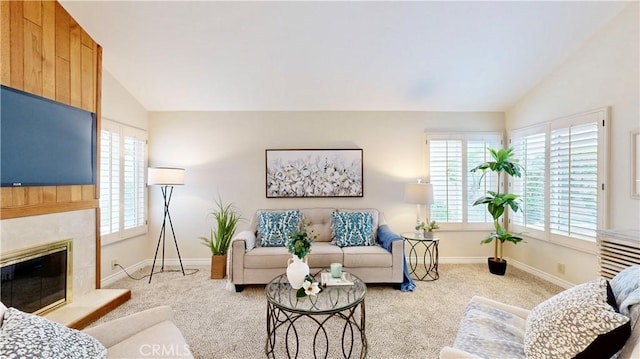 living area featuring baseboards, lofted ceiling, carpet flooring, and plenty of natural light