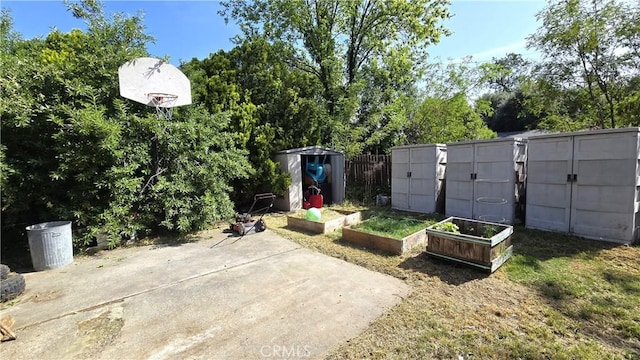 1954 Elizabeth Ave, Corning, CA 96021 - exterior space featuring fence, a vegetable garden, an outbuilding, and a storage shed
