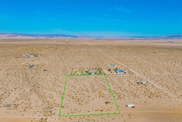 aerial view featuring a rural view, view of desert, and a mountain view