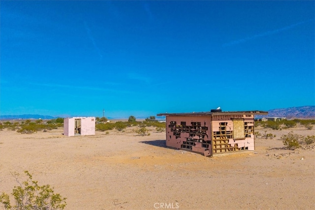 exterior space featuring a desert view and a mountain view