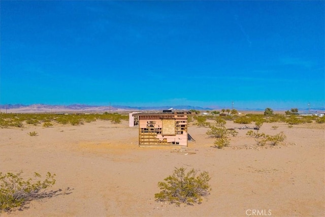 exterior space featuring a rural view, view of desert, and a mountain view