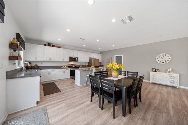 dining room featuring baseboards, light wood finished floors, recessed lighting, and visible vents
