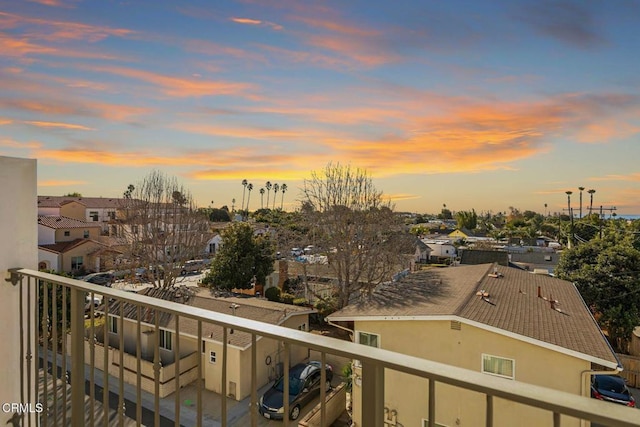 balcony at dusk featuring a residential view