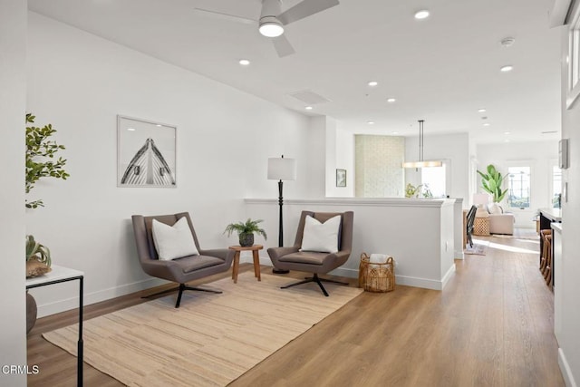living area with baseboards, recessed lighting, a ceiling fan, and light wood-type flooring