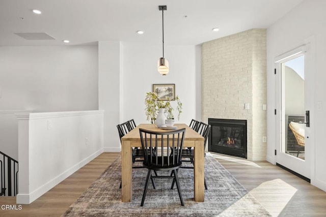 dining space with recessed lighting, wood finished floors, a fireplace, and baseboards