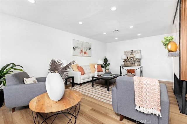living room featuring recessed lighting, light wood-style floors, visible vents, and baseboards