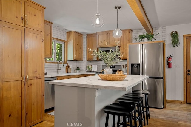 29387 Lake View Dr, Cedar Glen, CA 92321 - kitchen with appliances with stainless steel finishes, tasteful backsplash, light wood-style floors, a center island, and a kitchen breakfast bar