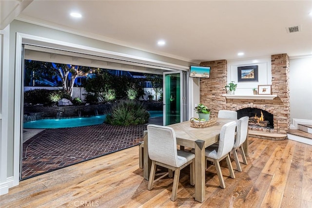 1232 Blue Gum Ln, Newport Beach, CA 92660 - dining area with visible vents, hardwood / wood-style floors, ornamental molding, and a stone fireplace