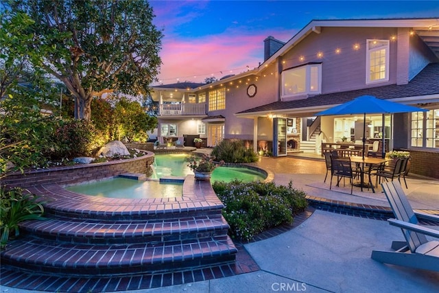 1232 Blue Gum Ln, Newport Beach, CA 92660 - rear view of property with stucco siding, an in ground hot tub, a patio area, a balcony, and an outdoor pool