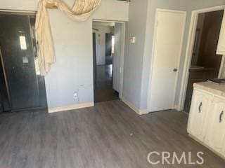 635 N 3rd St, Chowchilla, CA 93610 - unfurnished dining area featuring baseboards and dark wood-style floors