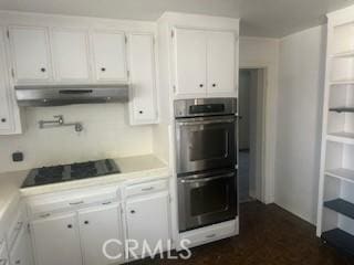 635 N 3rd St, Chowchilla, CA 93610 - kitchen with double oven, under cabinet range hood, white cabinetry, and light countertops