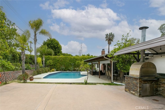 pool with grilling area, a gazebo, exterior kitchen, and a patio area