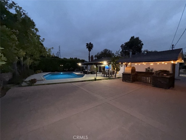 pool featuring exterior kitchen and a patio area