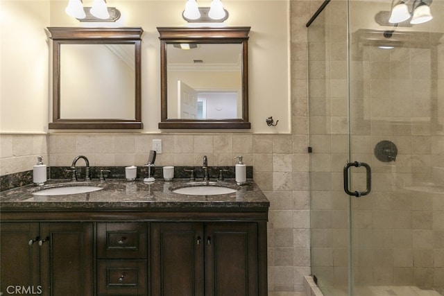 full bathroom featuring a sink, a stall shower, and double vanity