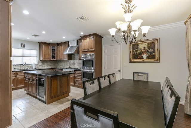 kitchen featuring visible vents, tasteful backsplash, beverage cooler, and stainless steel appliances