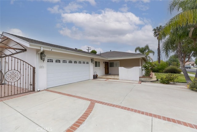 view of front of home featuring concrete driveway, stucco siding, and a garage