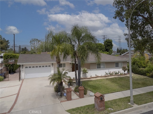 ranch-style home with roof with shingles, a garage, stucco siding, a front yard, and driveway