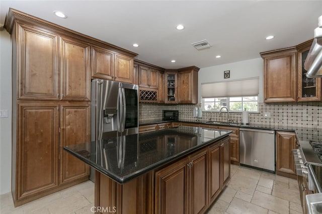 kitchen featuring a sink, stainless steel appliances, recessed lighting, tasteful backsplash, and stone tile flooring