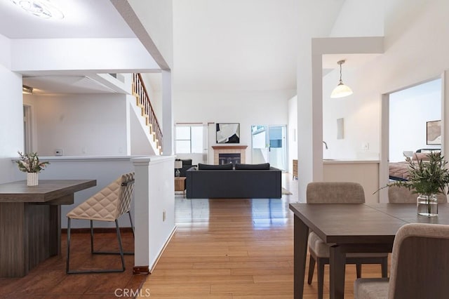 interior space with stairs, wood finished floors, a high ceiling, and a fireplace