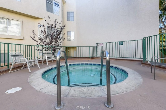 view of pool with a hot tub