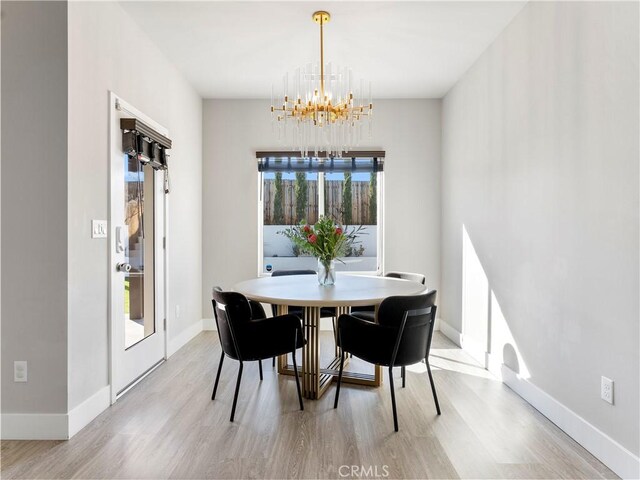 5211 Wingspan Ln, Bakersfield, CA 93306 - dining area with baseboards, a notable chandelier, and light wood-style floors