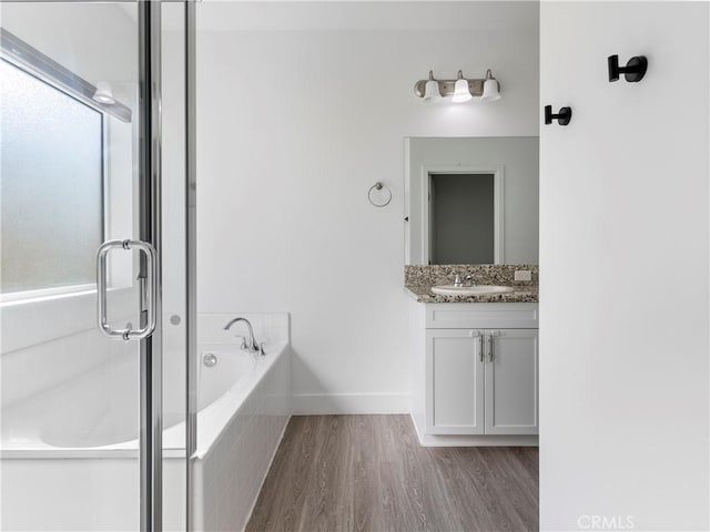 5211 Wingspan Ln, Bakersfield, CA 93306 - bathroom with a shower stall, a garden tub, baseboards, wood finished floors, and vanity