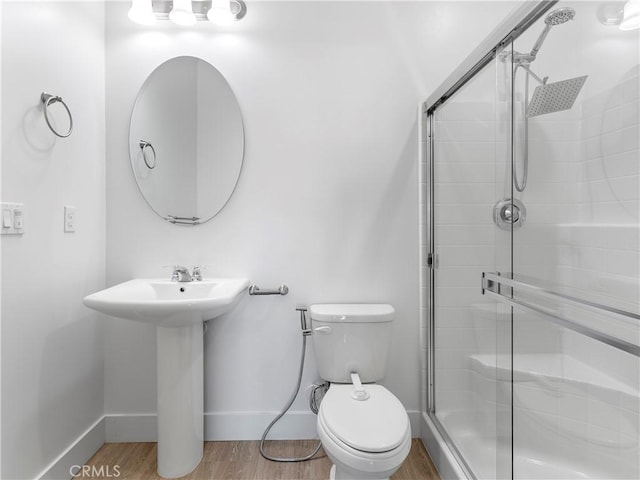 5211 Wingspan Ln, Bakersfield, CA 93306 - bathroom featuring wood finished floors, toilet, a stall shower, and baseboards