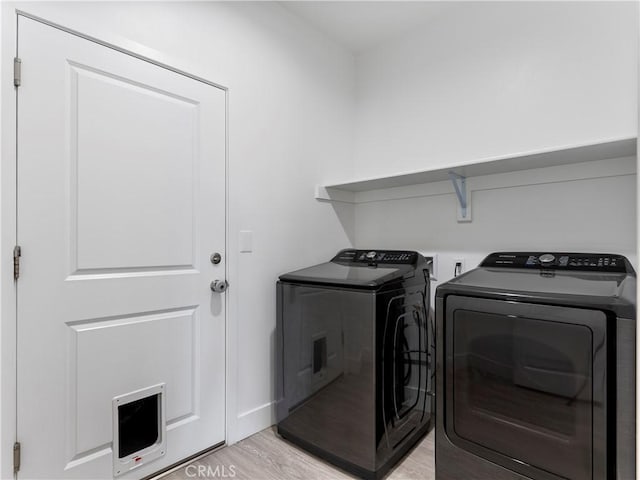 5211 Wingspan Ln, Bakersfield, CA 93306 - clothes washing area featuring independent washer and dryer, light wood-style flooring, and laundry area