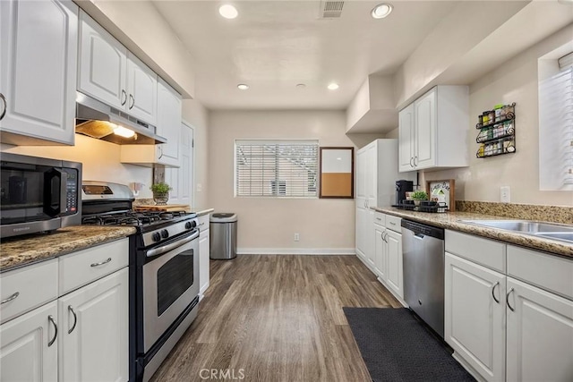 1229 Central Ave, Fullerton, CA 92831 - kitchen with appliances with stainless steel finishes, under cabinet range hood, white cabinetry, dark wood-style floors, and recessed lighting