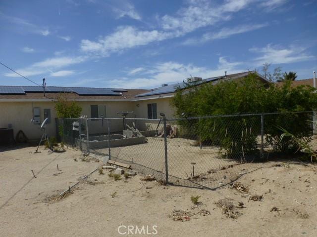 3465 Condor Rd Unit 29, Palms, CA 92277 - back of house with stucco siding, solar panels, and fence private yard