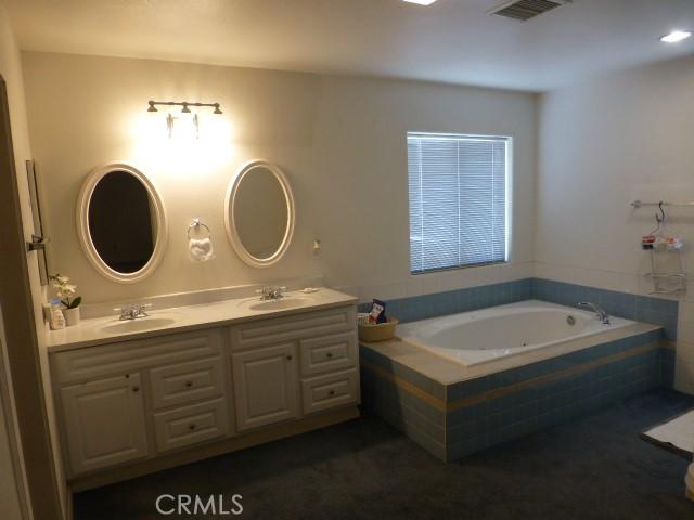 3465 Condor Rd Unit 29, Palms, CA 92277 - bathroom with double vanity, a bath, visible vents, and a sink